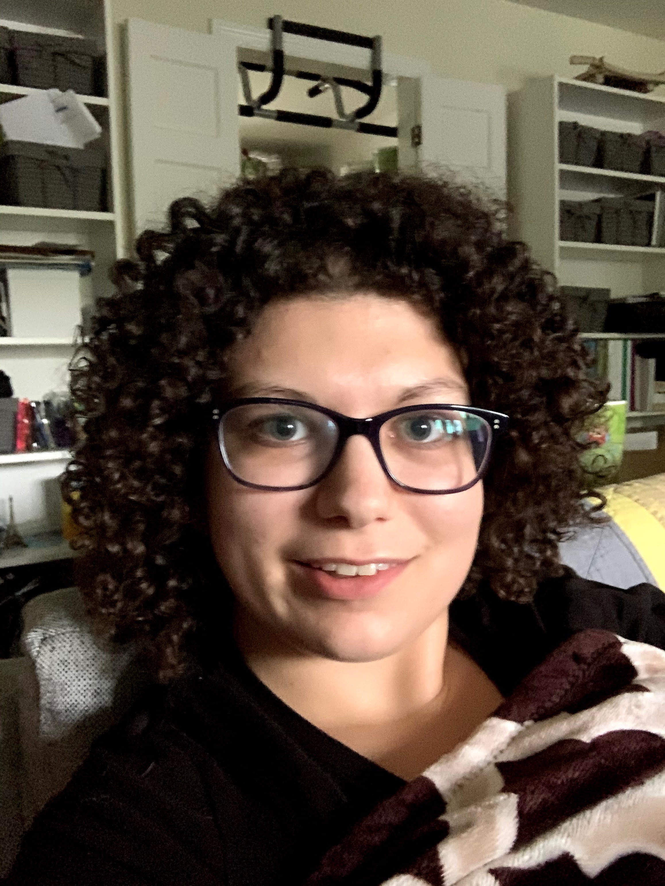 Ashley Ness, a woman with brown curly hair